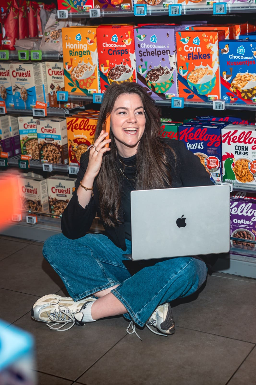 Grea van Supermarkt Marketing aan de telefoon tussen de schappen
